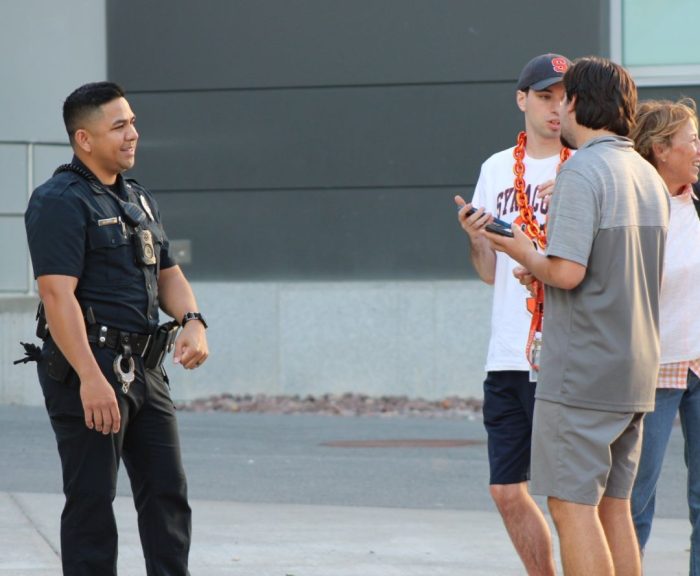 Officer Yoeun standing with students before an SU Football Game